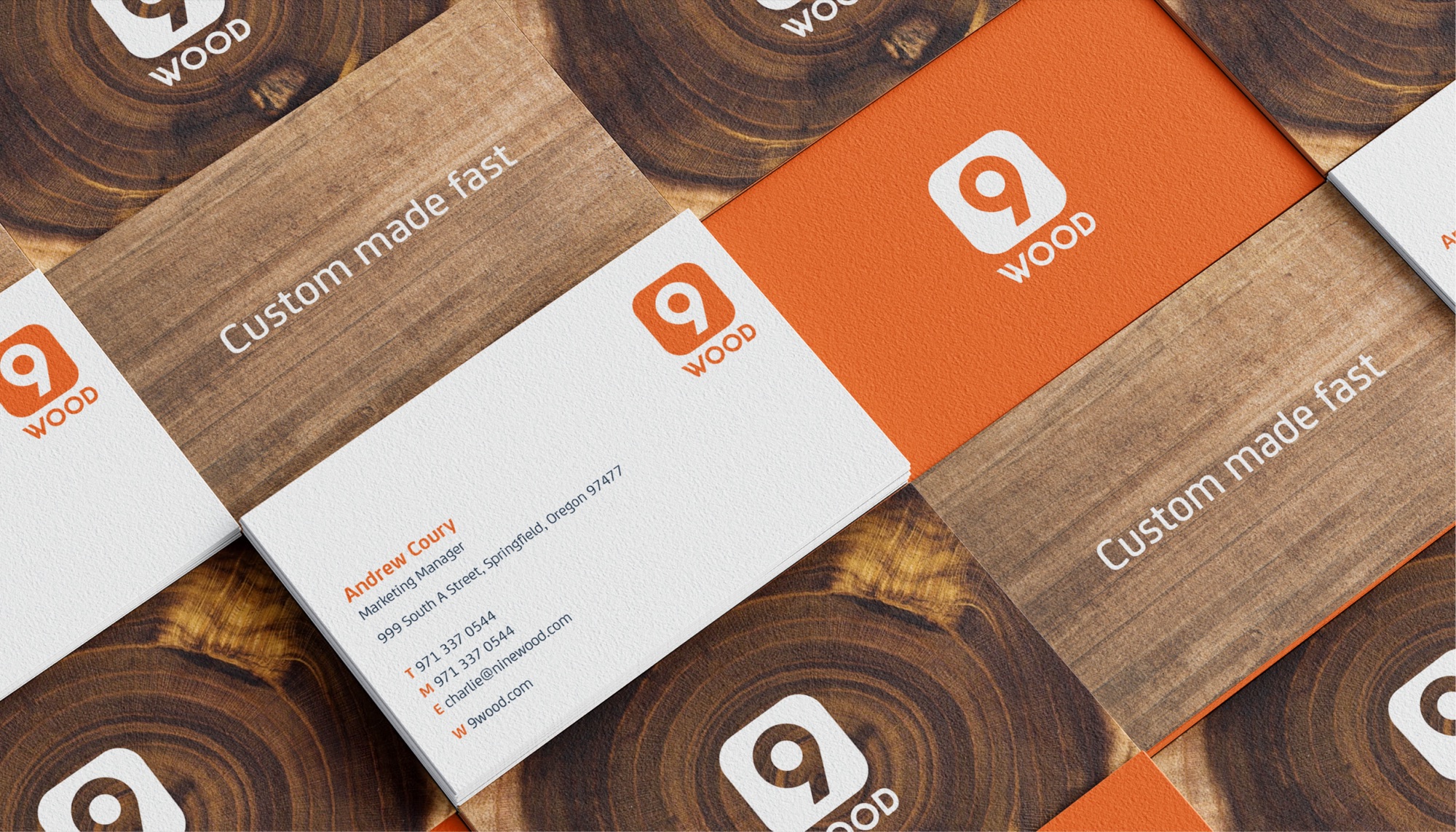 Business cards laid out in a tiled grid over end-grain and stained timber: white faces with the orange 9 logo and Andrew Coury’s contact details, orange reverses with the logo in white, and Custom made fast set across the wood-print backs