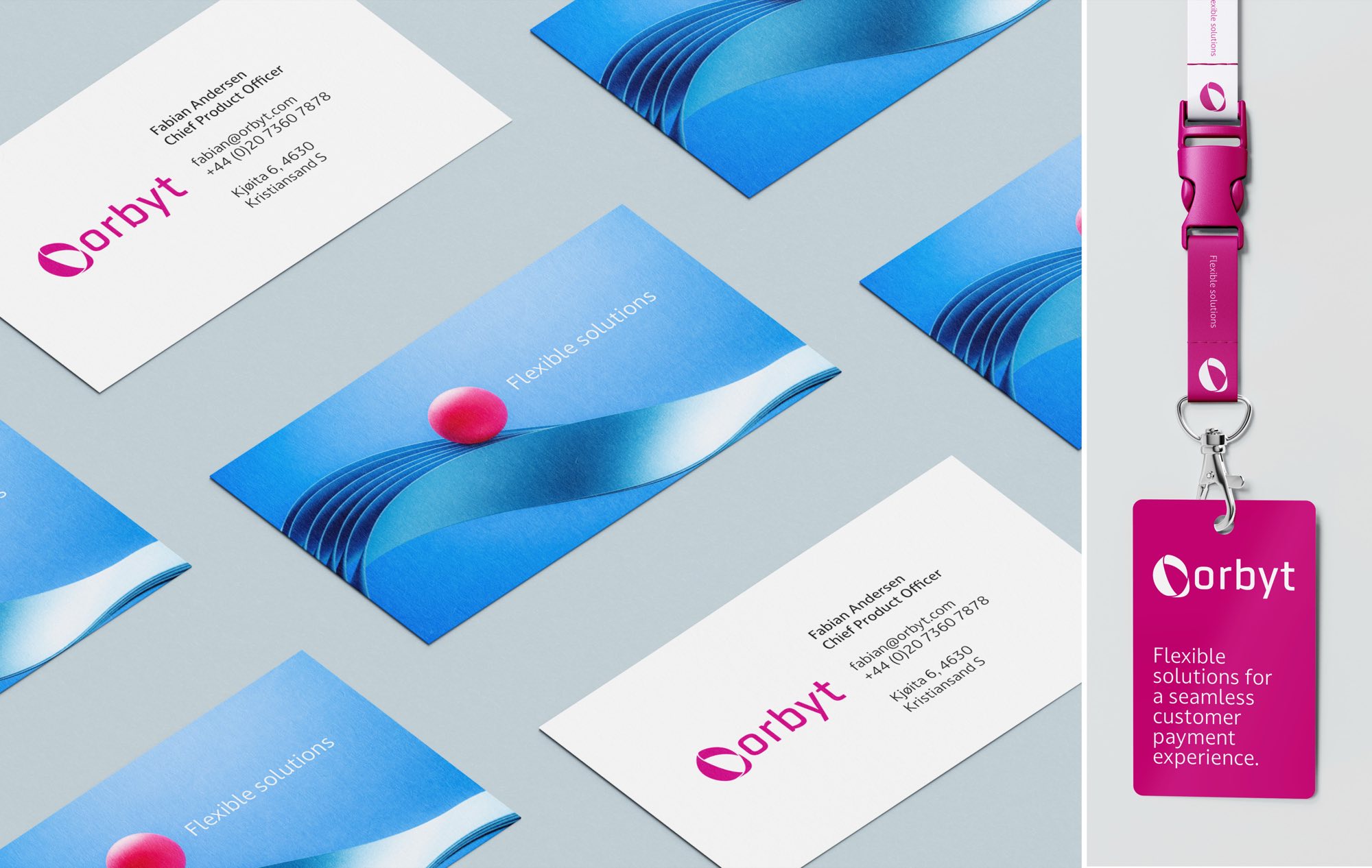 Stationery laid on grey: business cards with the magenta wordmark, reverse sides printed with the blue wave and sphere, and a magenta lanyard with a tag reading “Flexible solutions for a seamless customer payment experience”